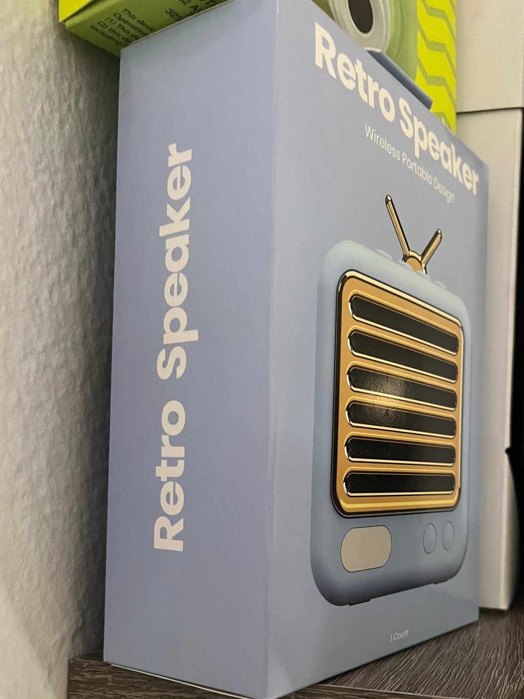 Retro speaker packaging on a shelf with a neutral background